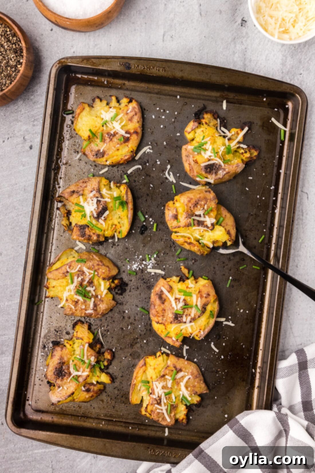 Smashed Potatoes on a sheet pan with a serving fork