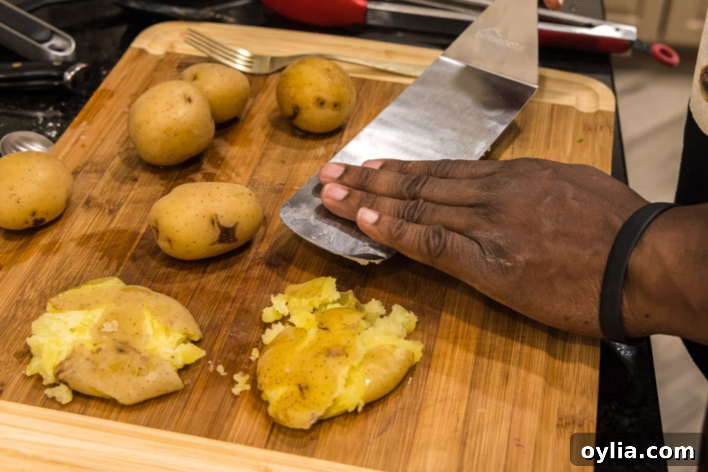 smashing yukon gold potatoes with a spatula