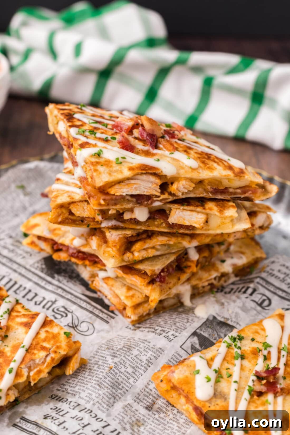 Stack of Chicken Bacon Ranch Quesadillas topped with ranch dressing, ready to be served for an easy lunch or dinner.