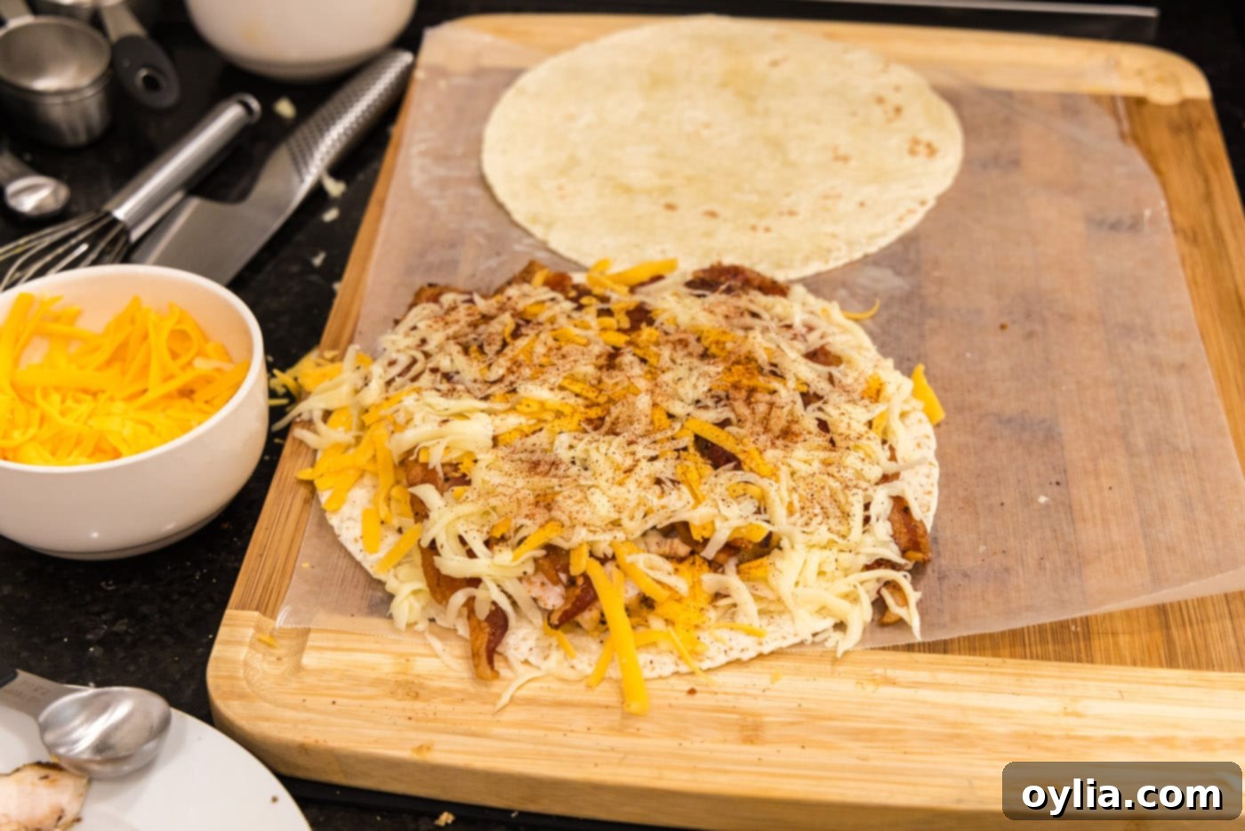 Chili powder sprinkled over chicken bacon ranch tortilla filling