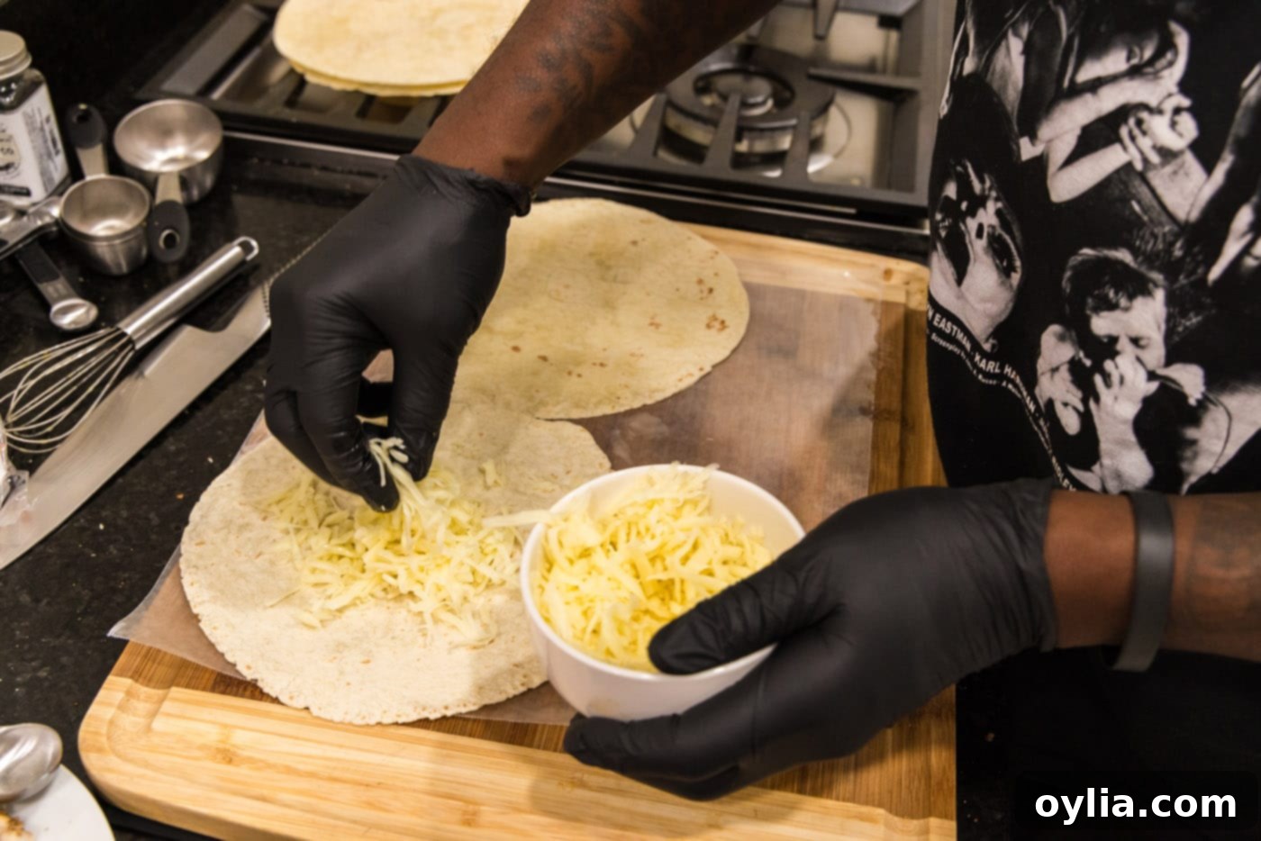 Adding shredded cheddar and mozzarella cheese to tortillas