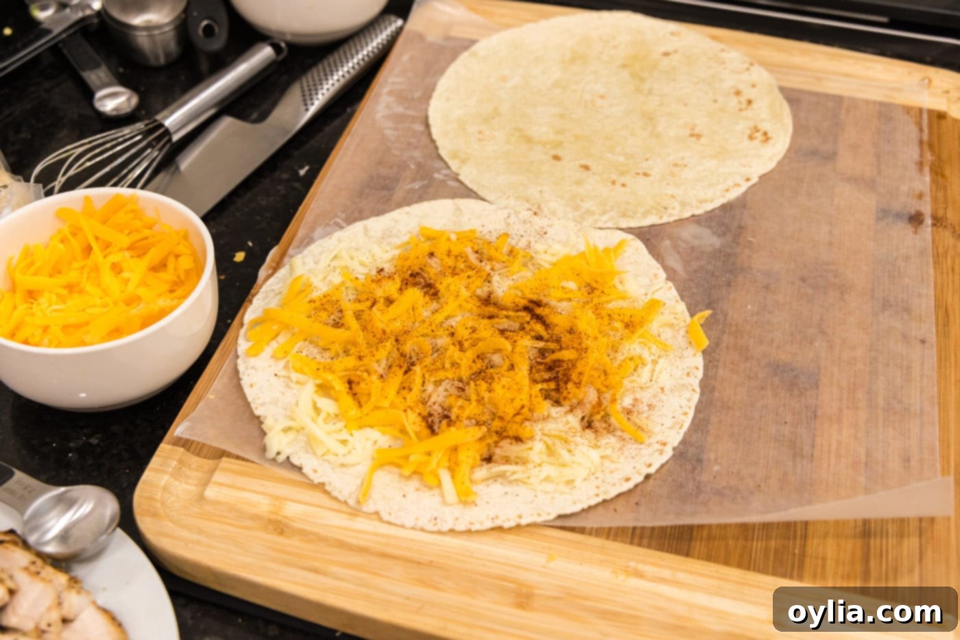 Chili powder sprinkled over cheese on a tortilla, adding a hint of spice