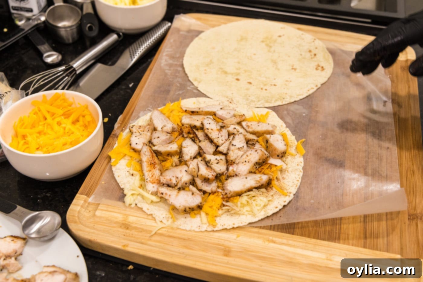 Sliced chicken breast layered over shredded cheese on a tortilla