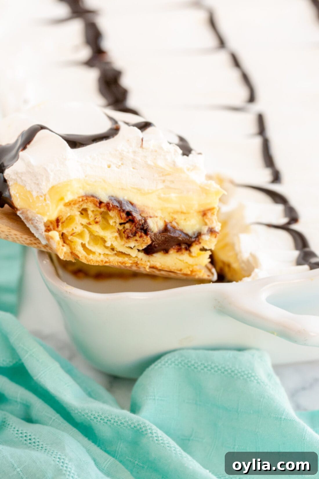 removing a slice of Cream Puff Chocolate Eclair Cake from pan