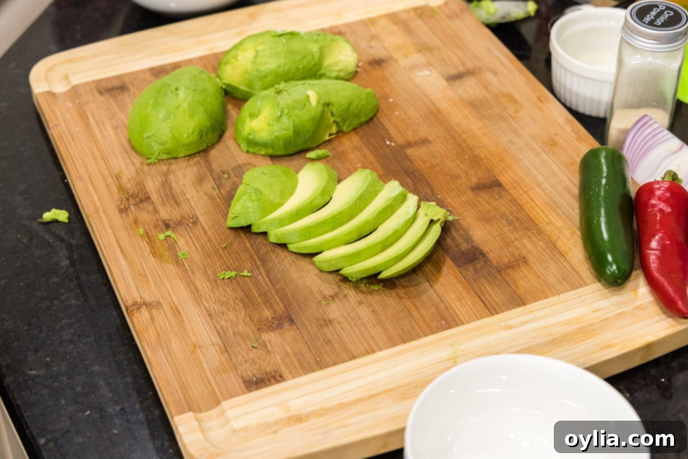 Perfectly sliced avocado pieces arranged on a cutting board, ready for breading