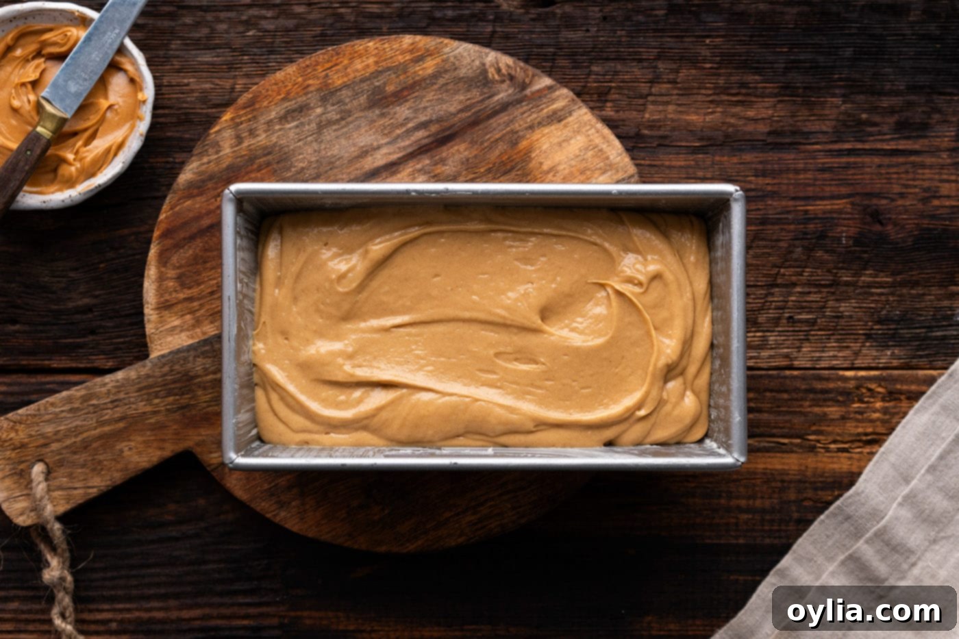 Peanut butter bread batter poured into the prepared loaf pan, ready for baking.