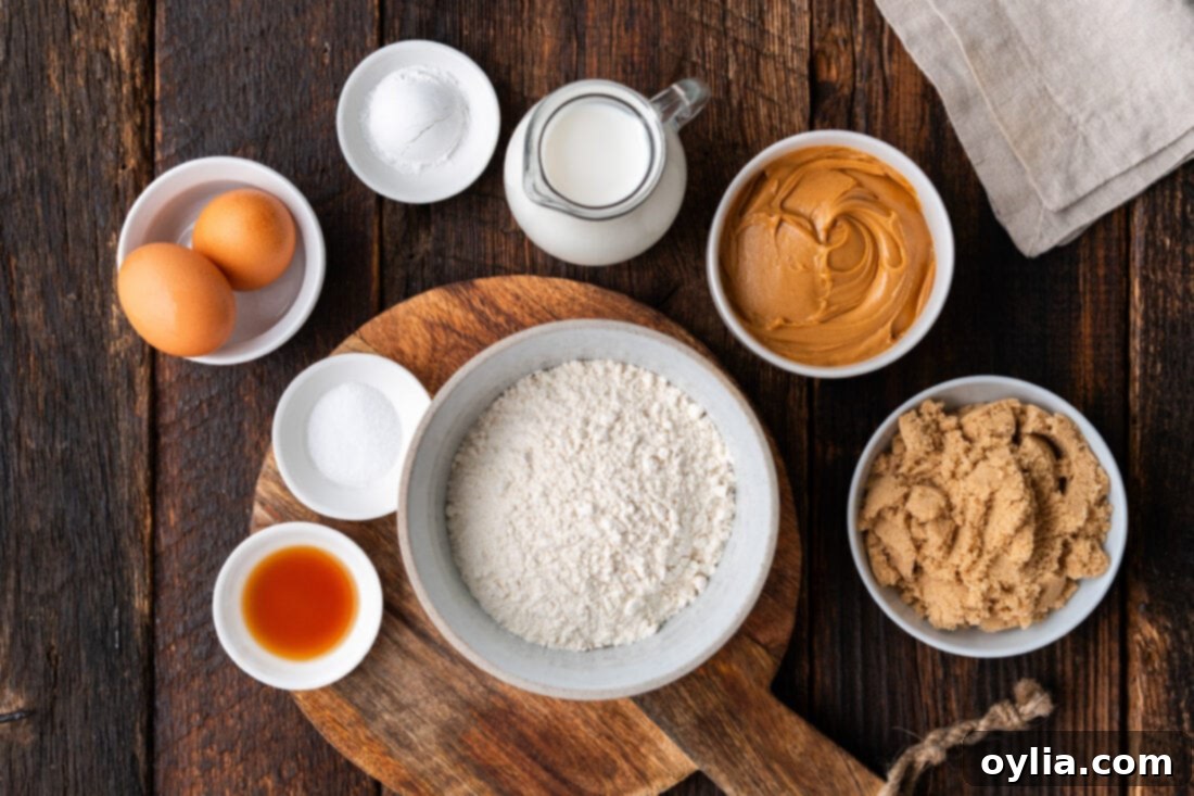 Collection of Ingredients for Peanut Butter Bread laid out on a kitchen counter, including peanut butter, flour, sugar, eggs, and milk.