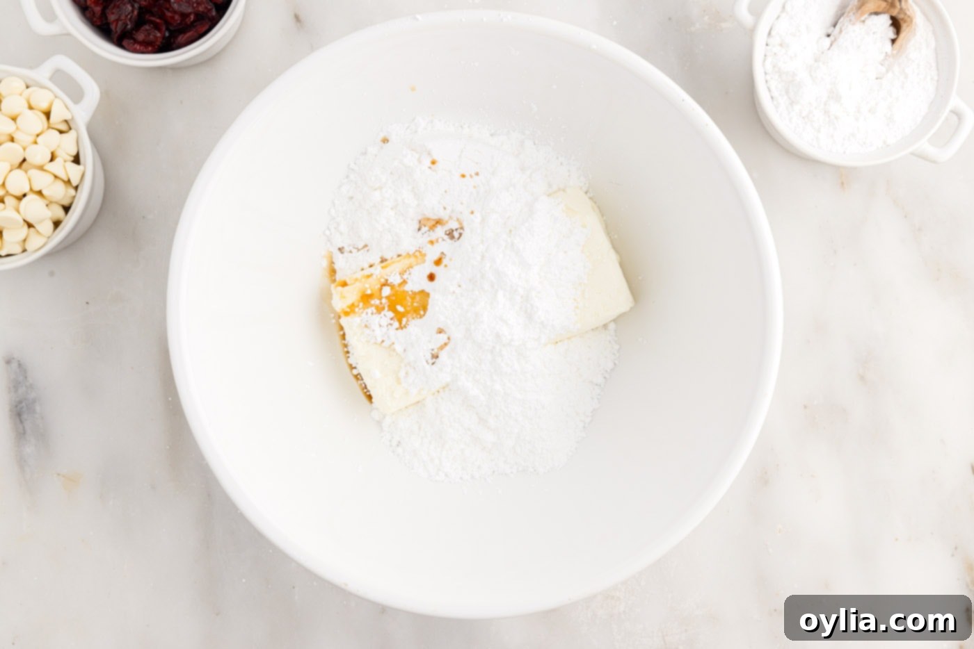 powdered sugar, cream cheese, and orange oil in a mixing bowl