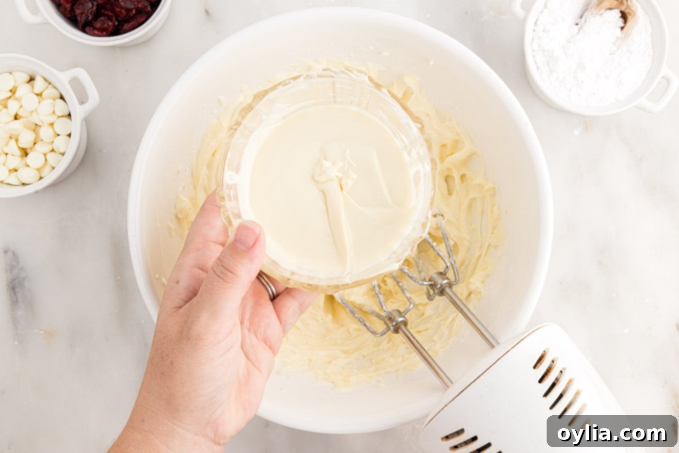 adding melted white chocolate to cream cheese frosting