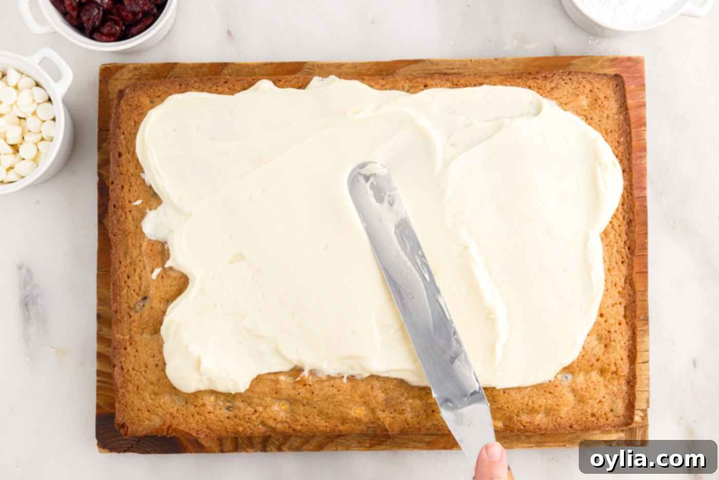spreading cream cheese frosting over baked blondies