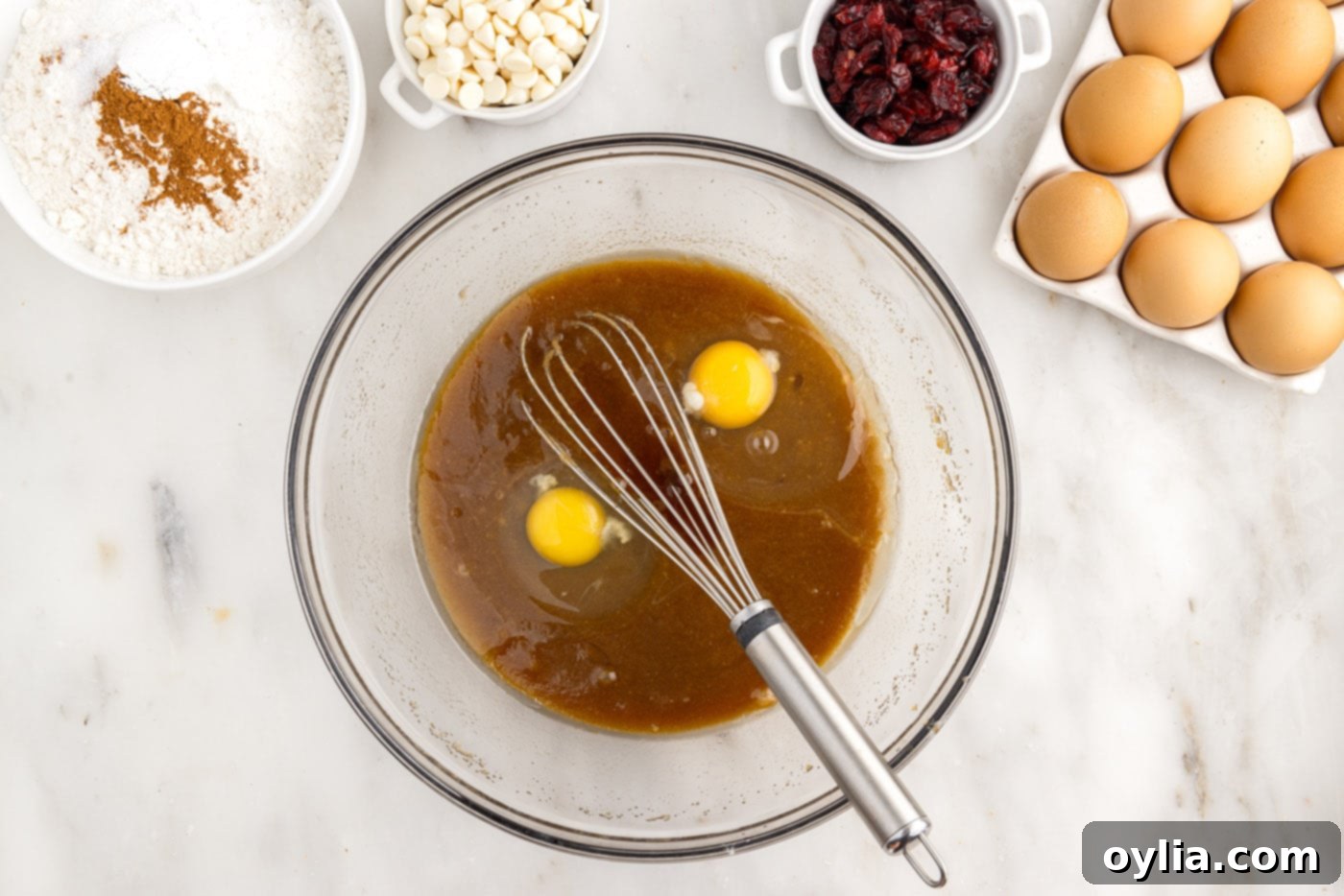 adding eggs to butter and sugar mixture in a bowl