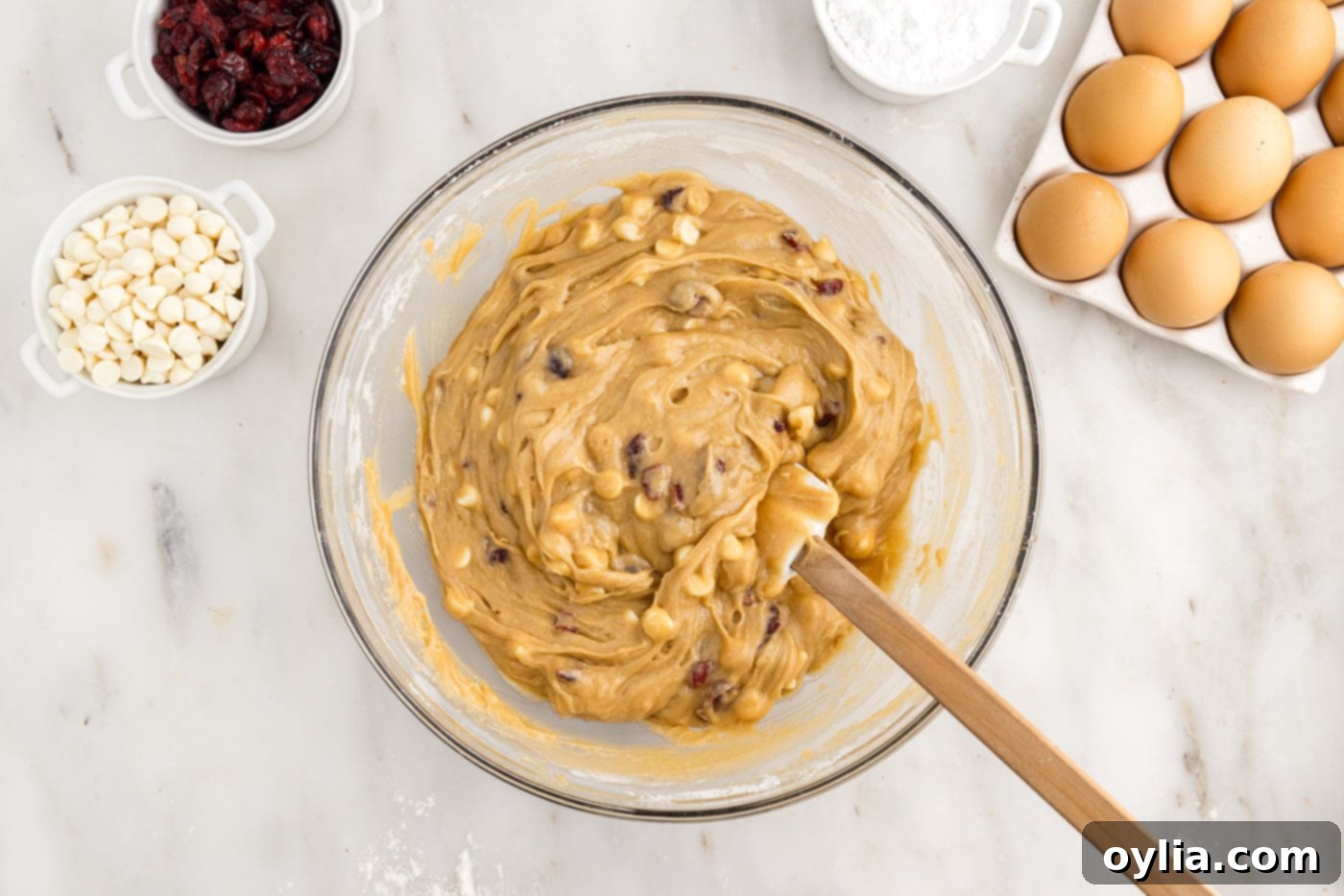 blondie dough with white chocolate chips and dried cranberries in a bowl