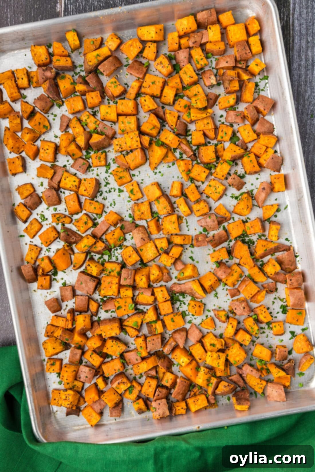 Baking sheet filled with evenly roasted sweet potatoes, perfectly browned and ready to serve.