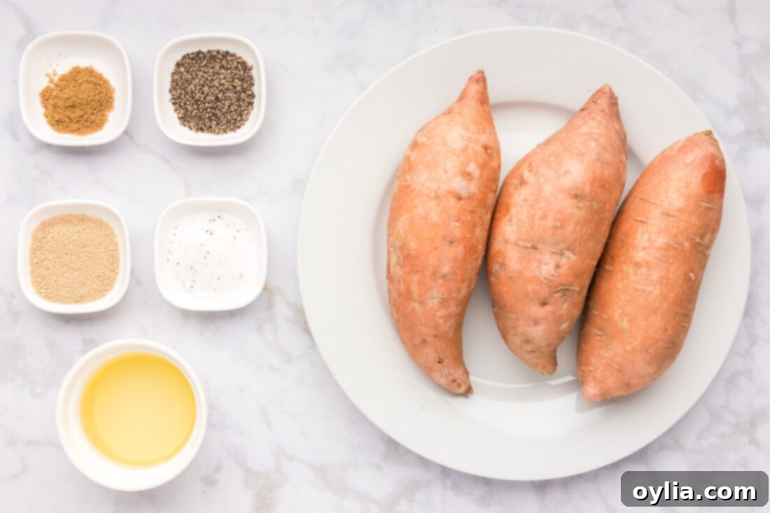 Close-up of fresh sweet potatoes, olive oil, brown sugar, coriander, salt, and pepper, all essential ingredients for this roasted sweet potato recipe.
