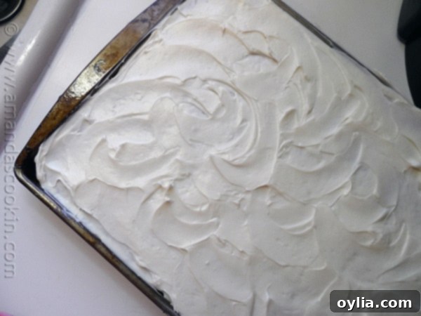 An overhead photo of a sheet pan of banana bars with vanilla cream cheese frosting.