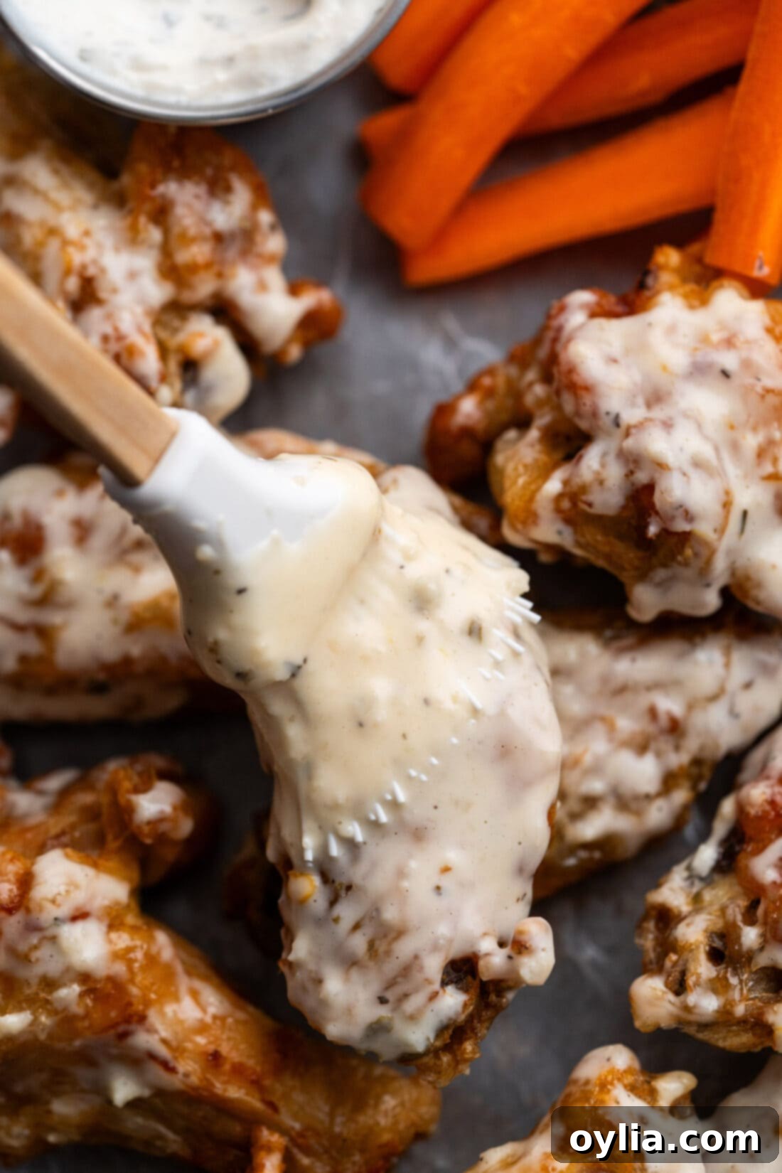 Garlic Parmesan Wing Sauce being brushed generously on crispy chicken wings.