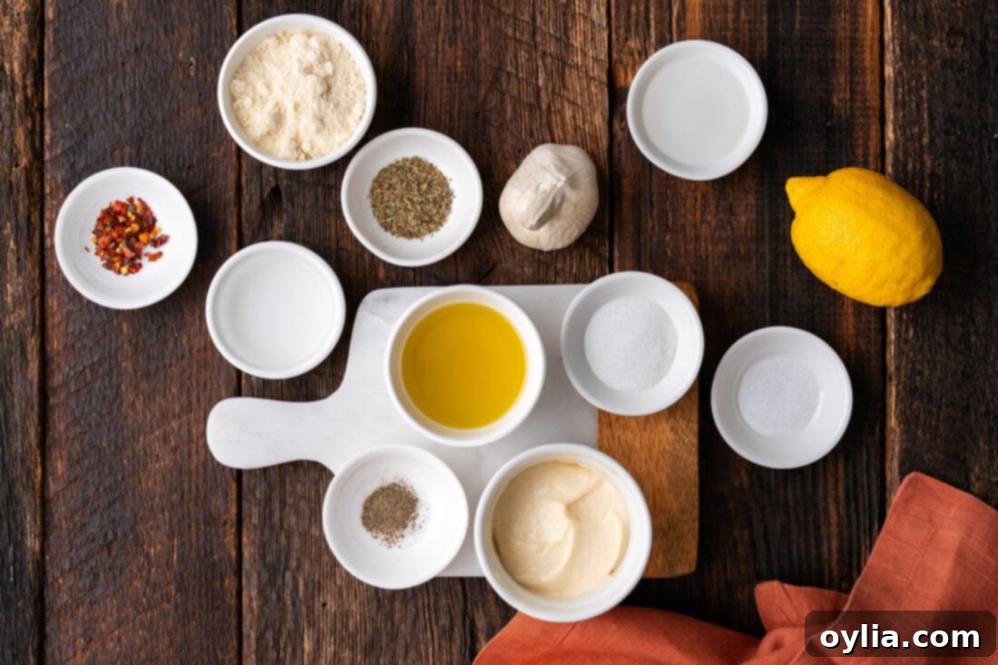 Arrangement of ingredients for homemade Garlic Parmesan Wing Sauce, including garlic, parmesan, oil, and spices.