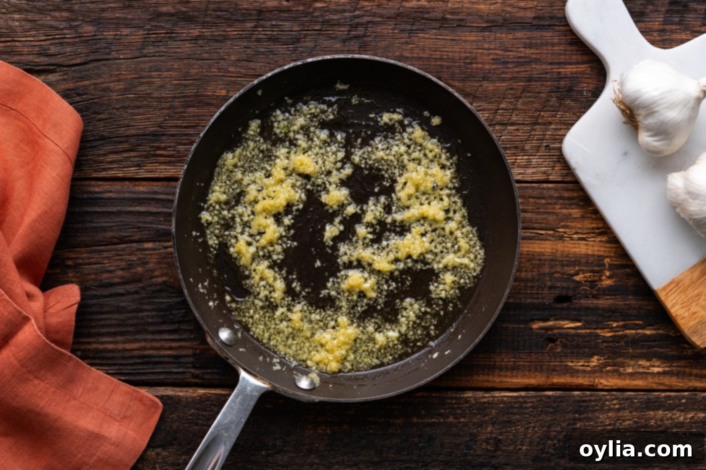 oil and minced garlic cooking in a skillet