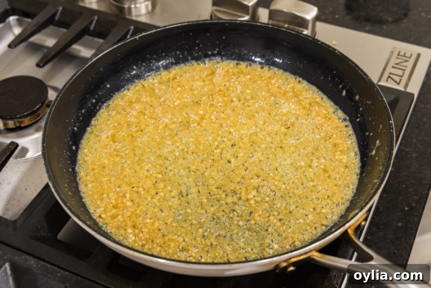 Rich, creamy garlic parmesan butter sauce in a skillet, ready for tossing with crispy wings.