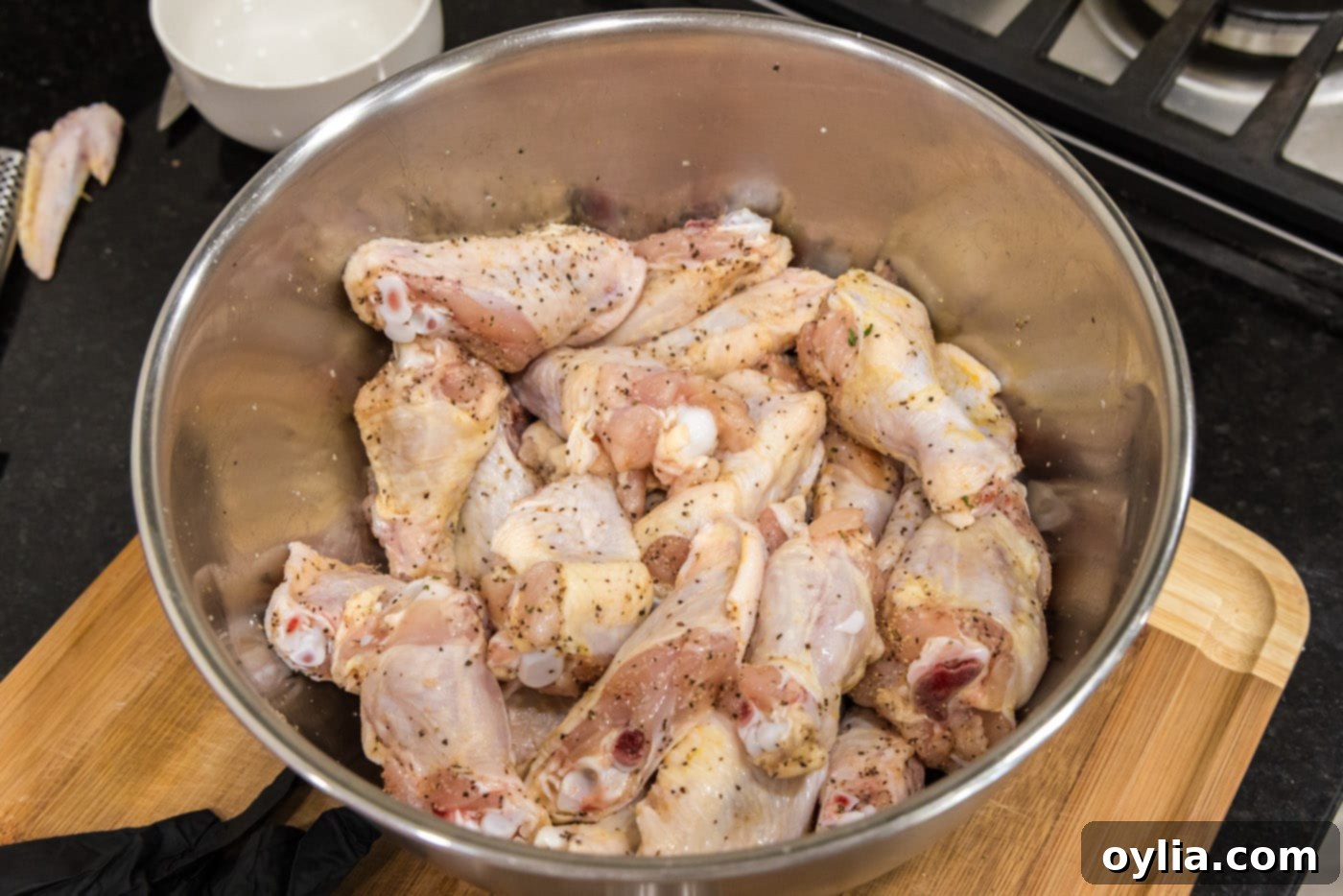 Seasoned chicken wings evenly coated with spices in a large mixing bowl, ready for frying.