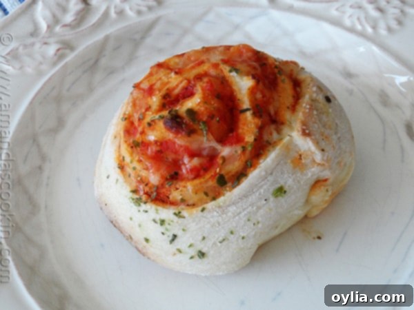 Close-up of freshly baked pizza roll ups, showcasing the bubbling melted cheese and golden, crispy crust.