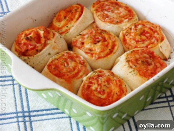 A fresh batch of golden-brown pizza roll ups, perfectly baked and cooling on a wire rack.