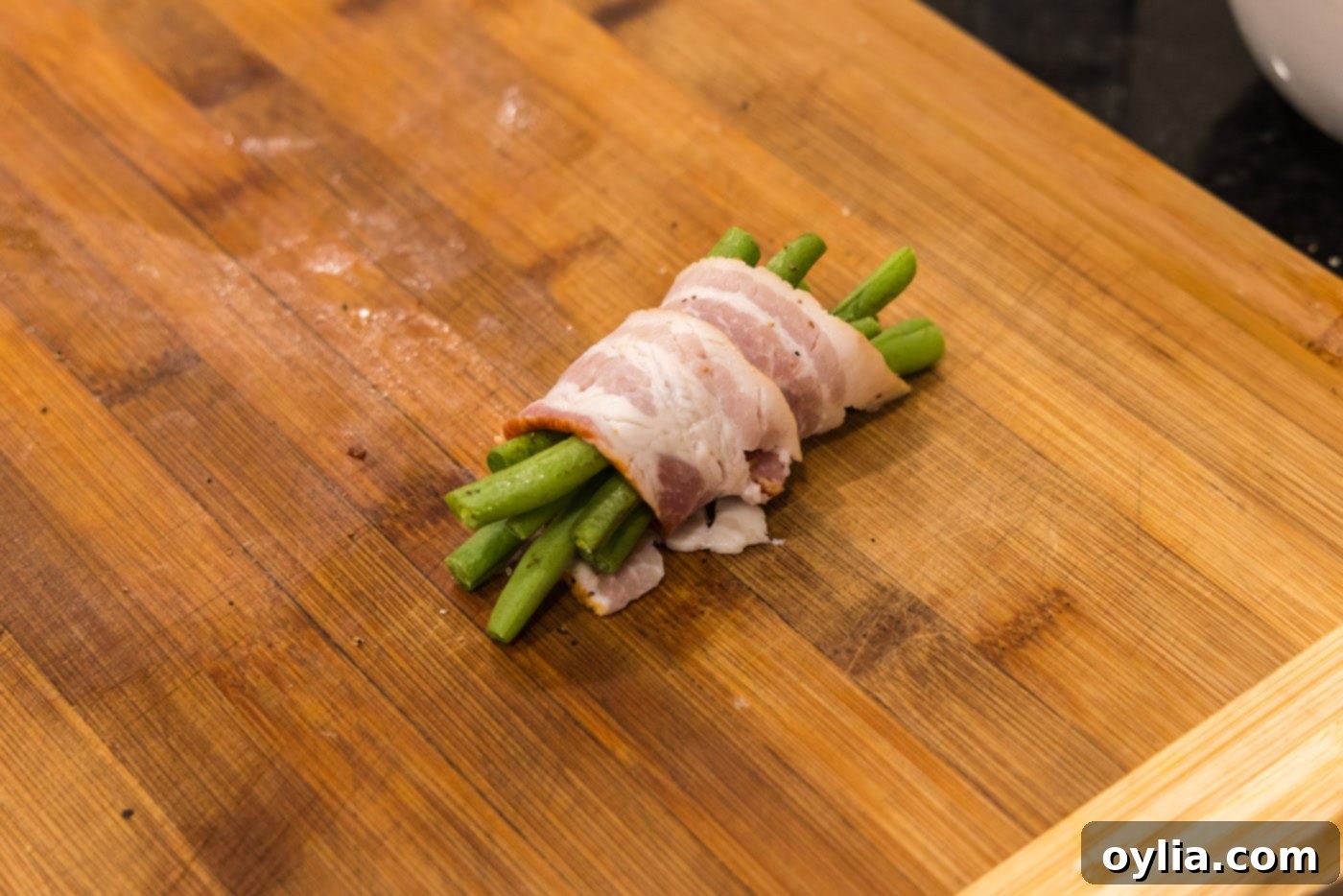 bacon wrapped green beans on a baking sheet