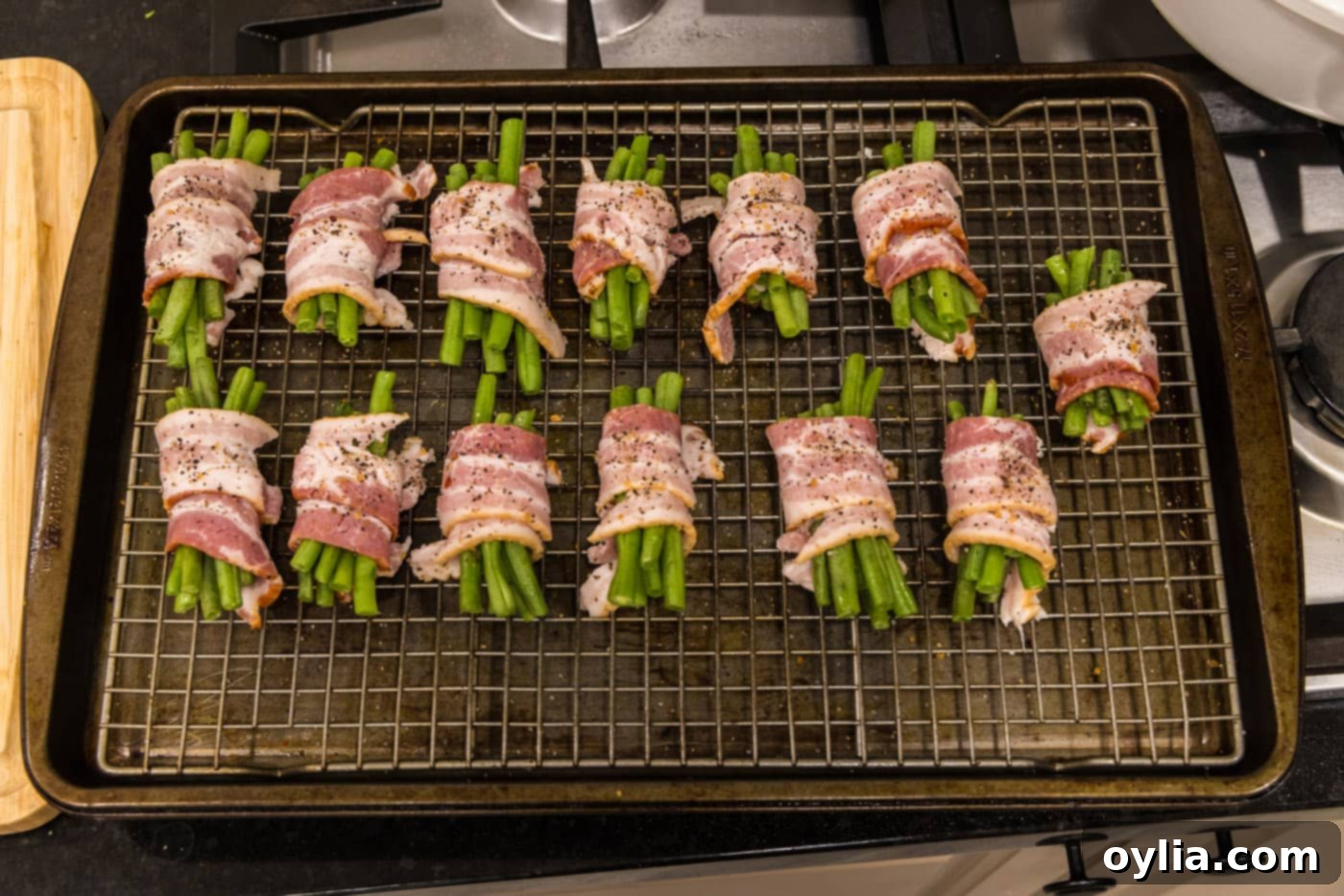 bacon wrapped green bean bundles on a baking sheet