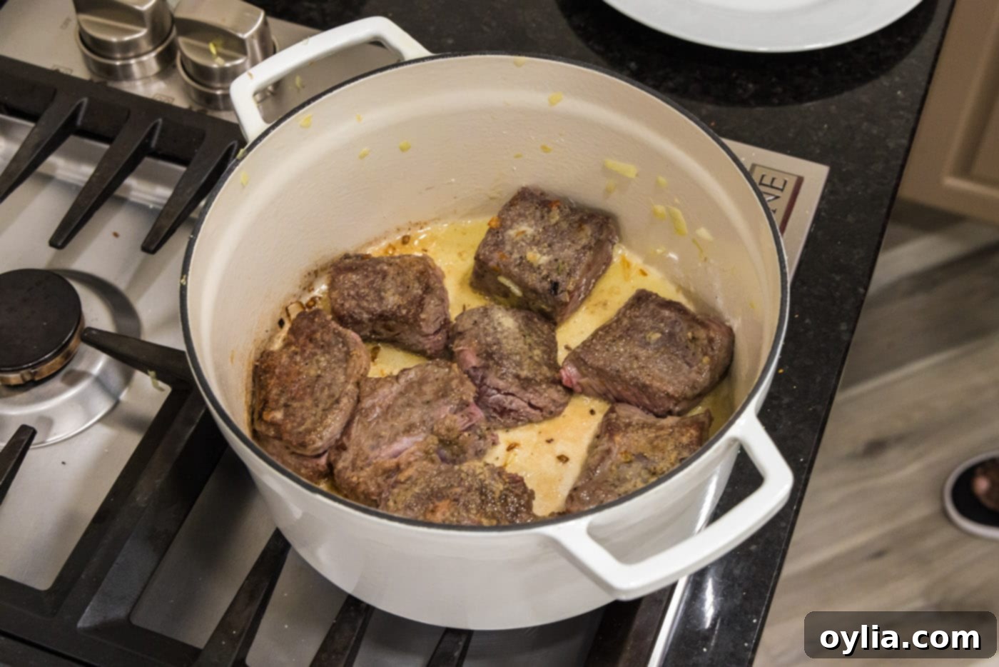Close-up of beef short ribs perfectly seared and browned on all sides in a cast-iron Dutch oven.
