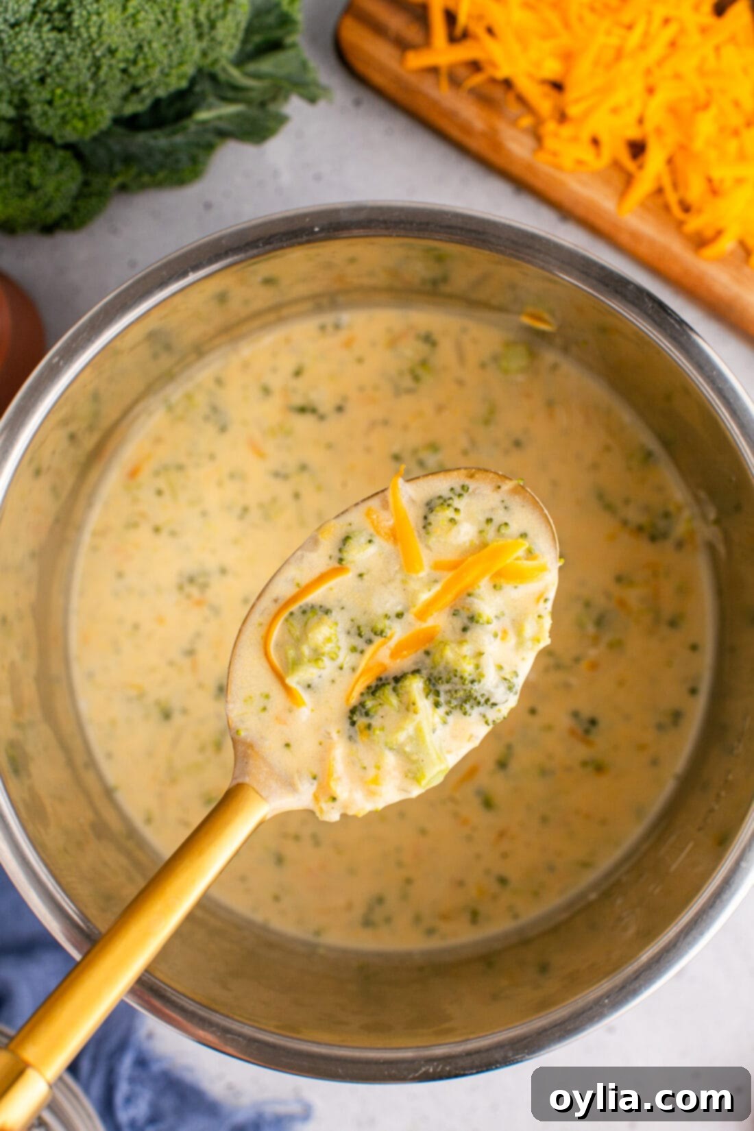 Spoonful of Instant Pot Broccoli Cheddar Soup being lifted above the instant pot