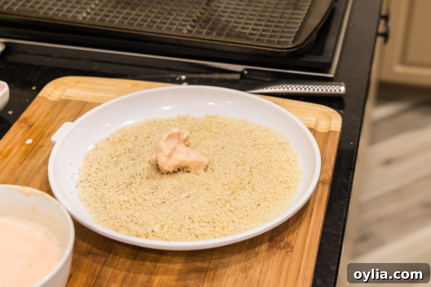 rolling dredged cauliflower in panko bread crumbs