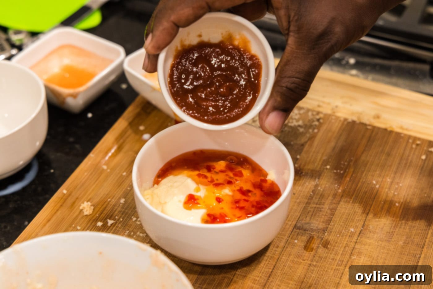 adding asian sweet chili sauce to mayo and sriracha mixture
