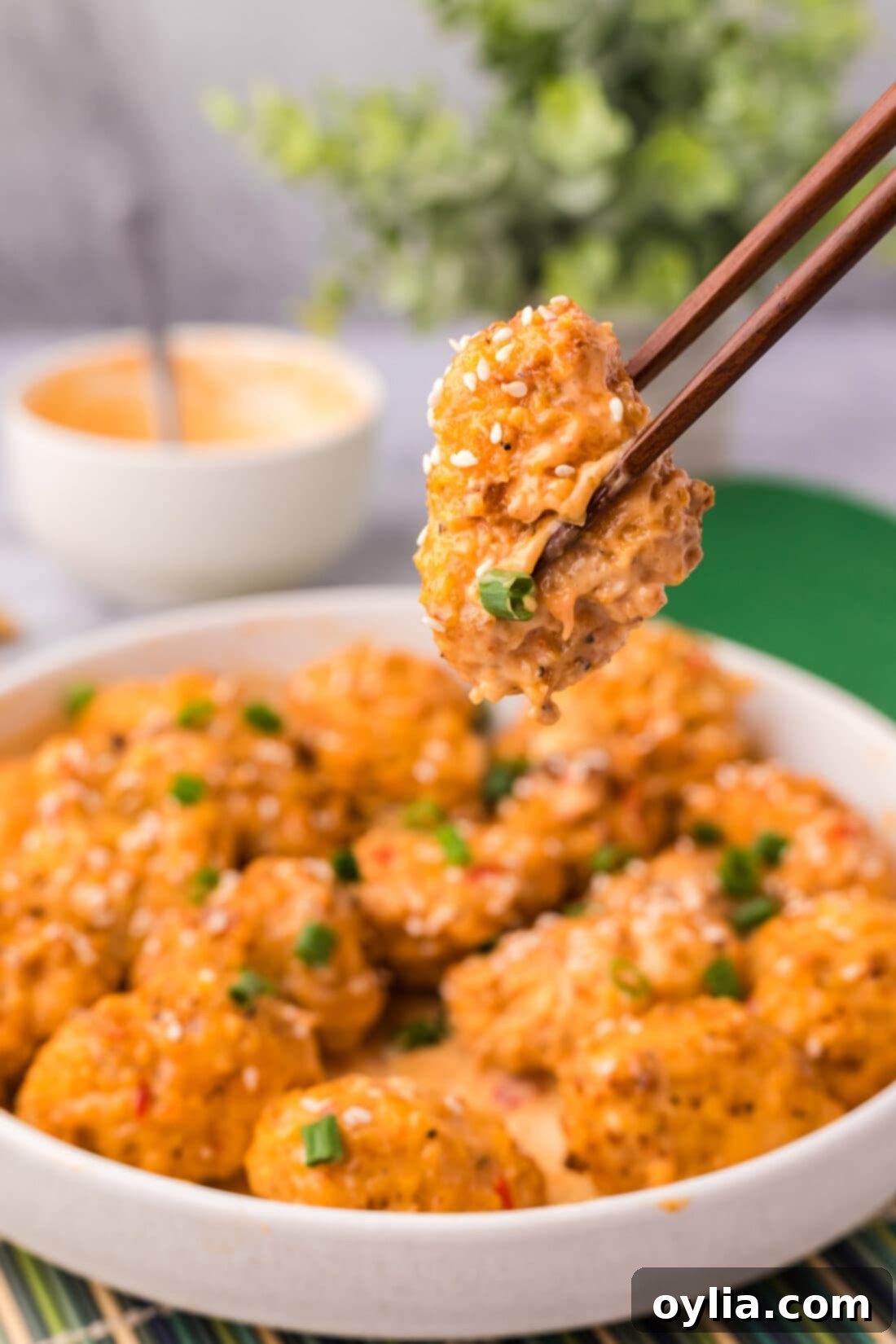 Chopsticks holding a piece of Bang Bang Cauliflower