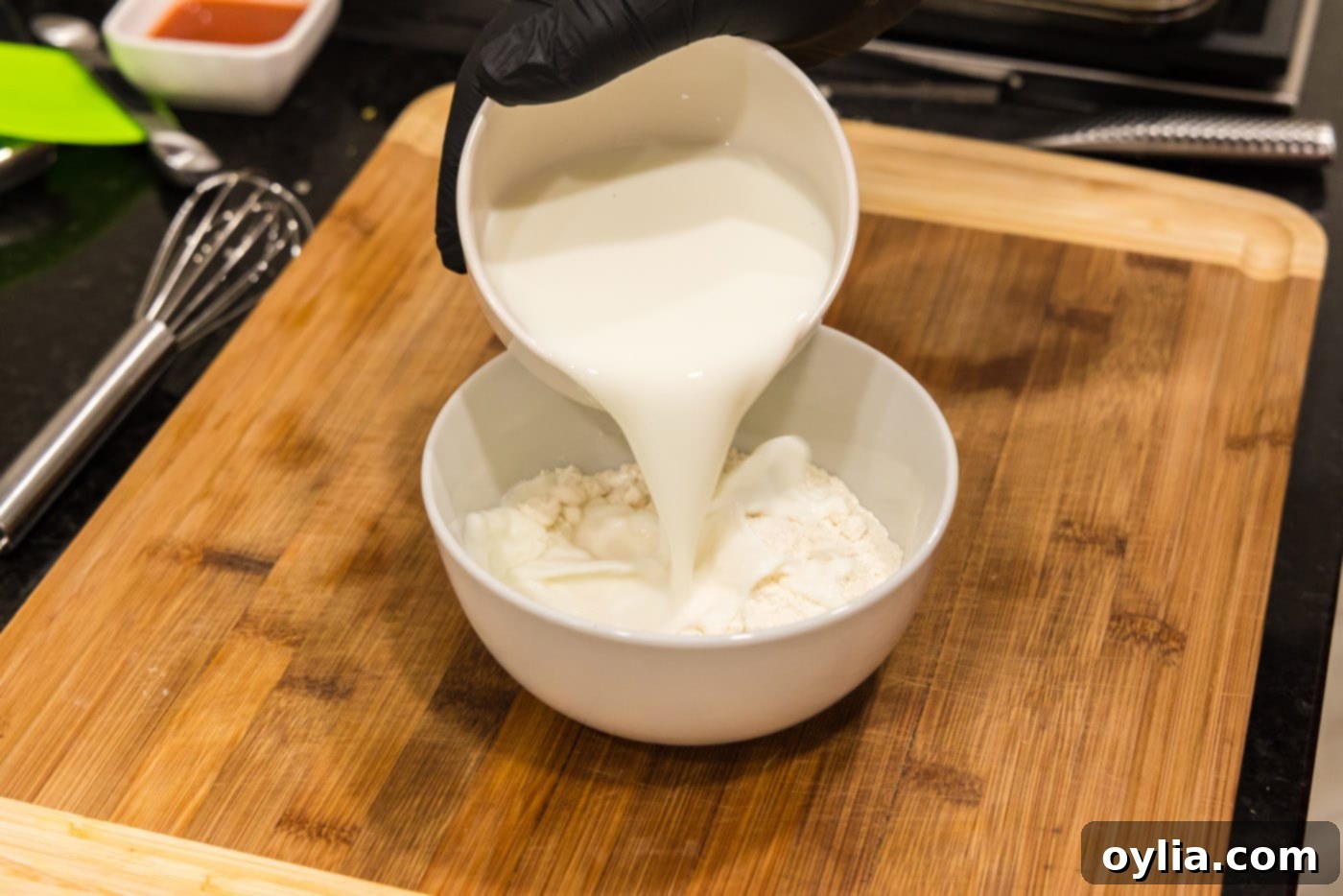 pouring buttermilk into flour in a bowl