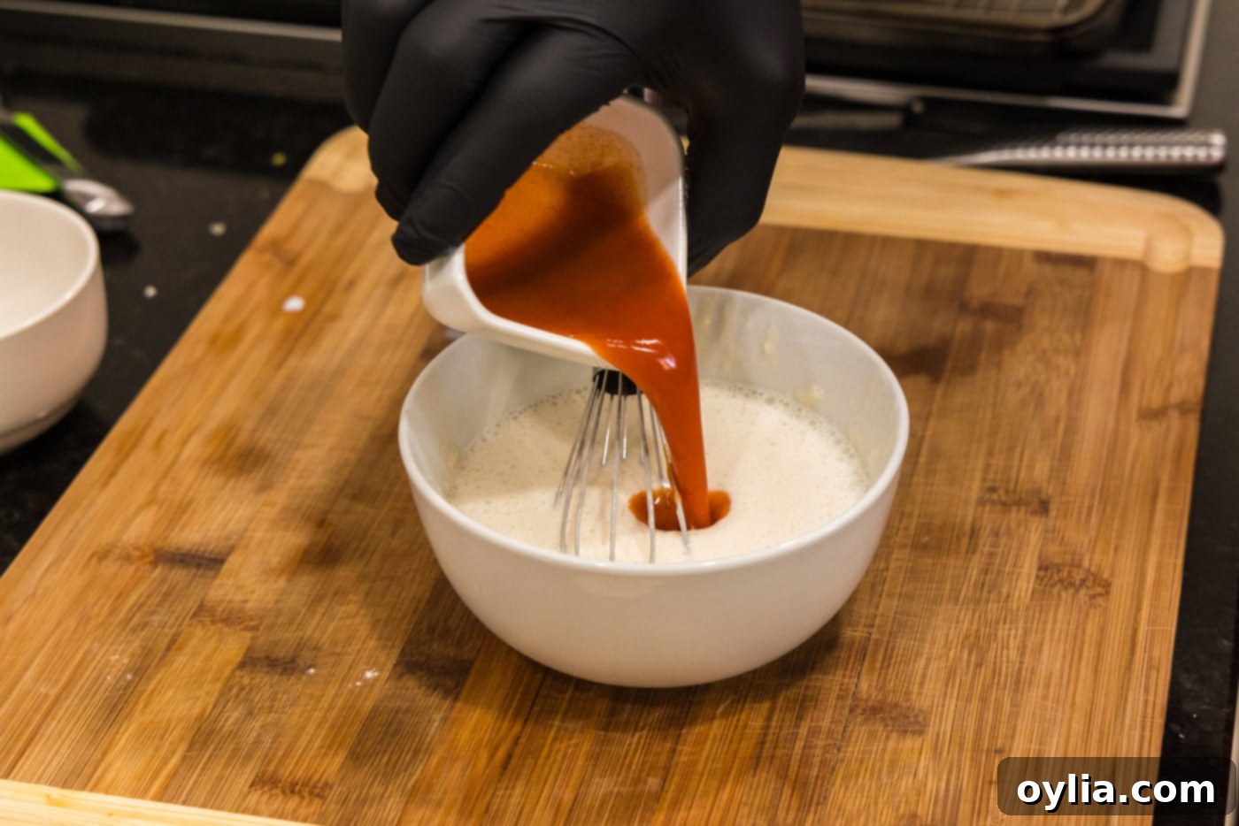 adding hot sauce to flour and buttermilk mixture