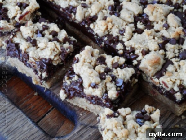An overhead photo of peanut butter chocolate layer bars resting on a wooden cutting board.