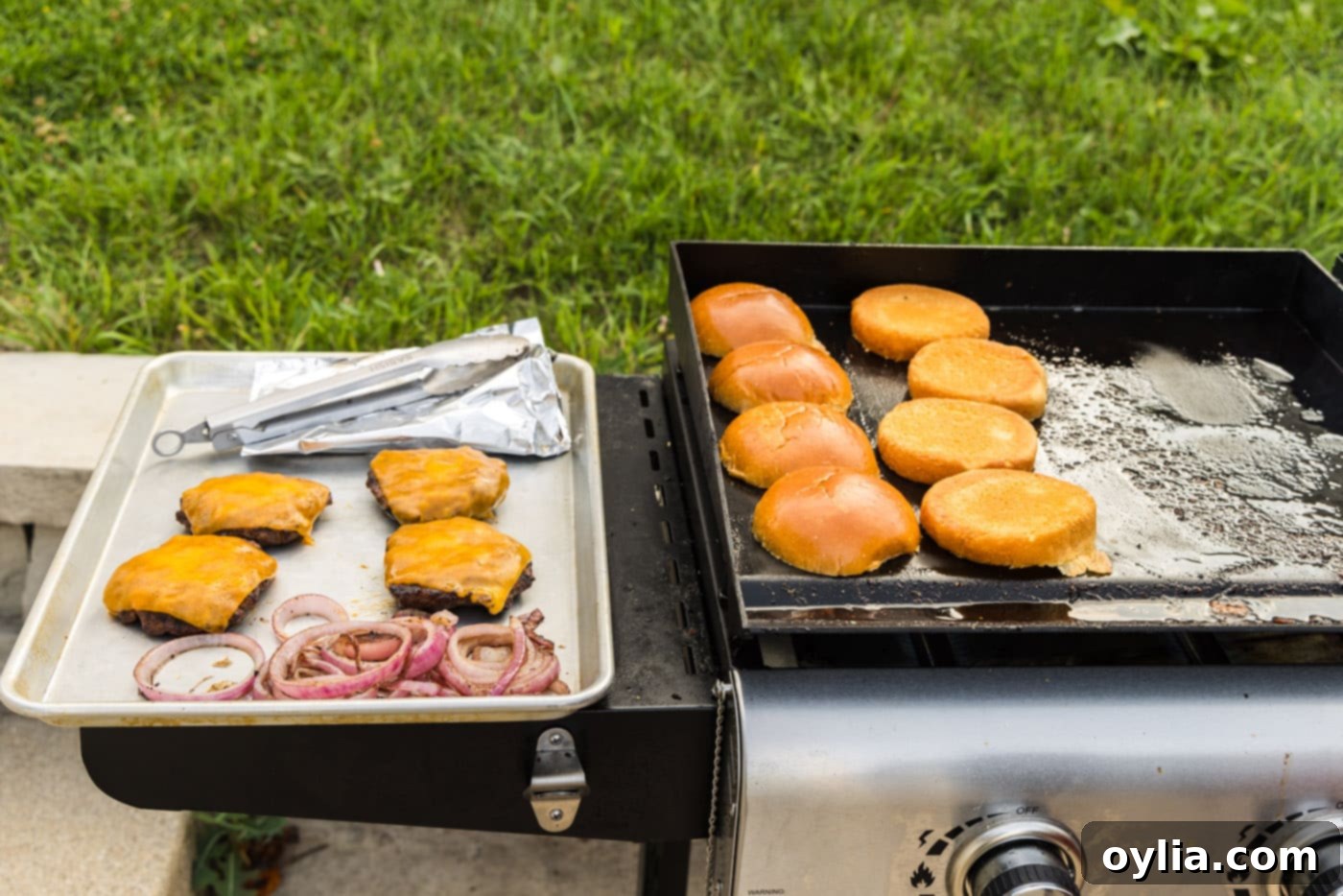 buns, burger patties, and grilled onions on the grill