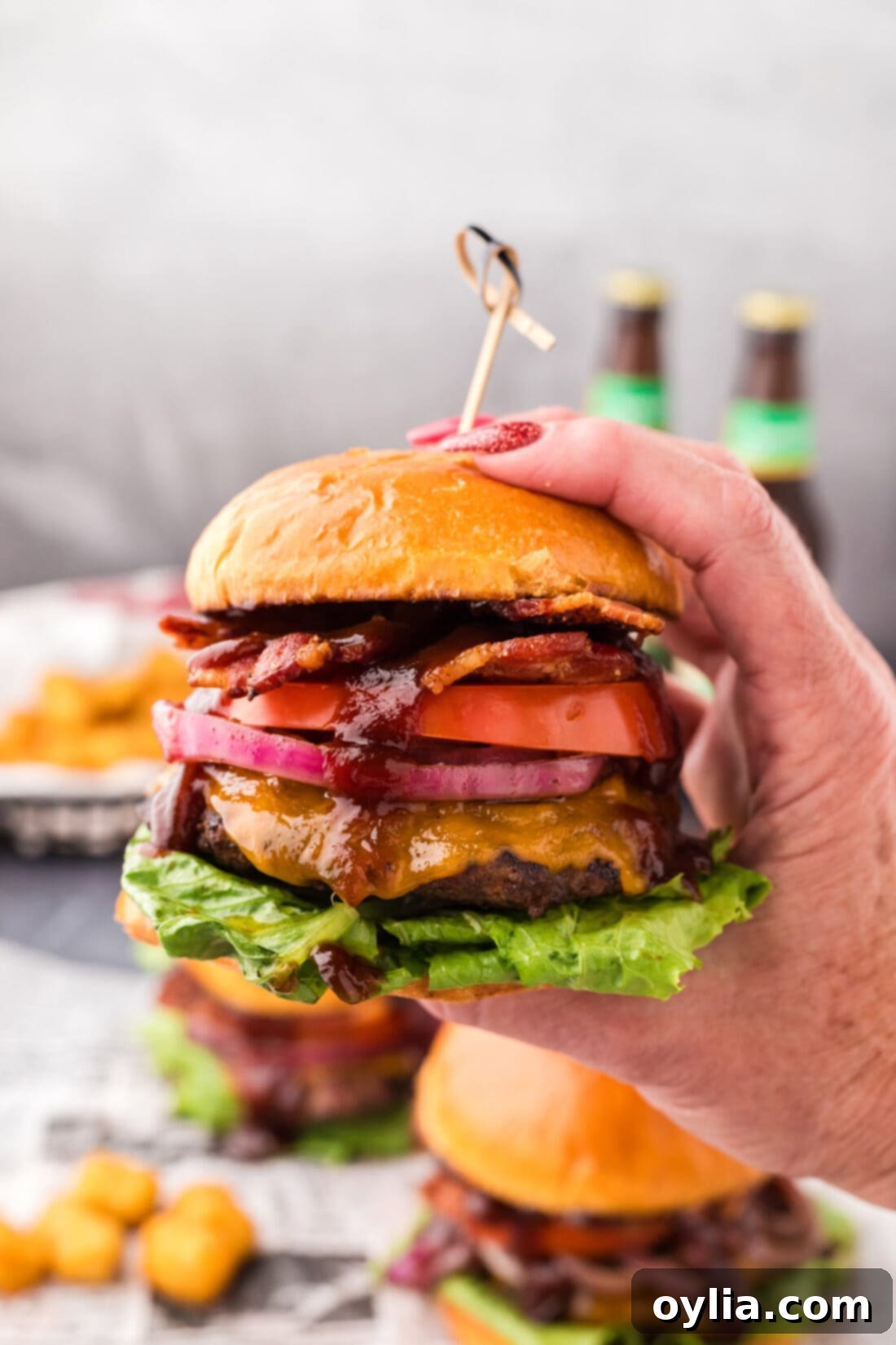 Hand holding up a BBQ Bacon Burger