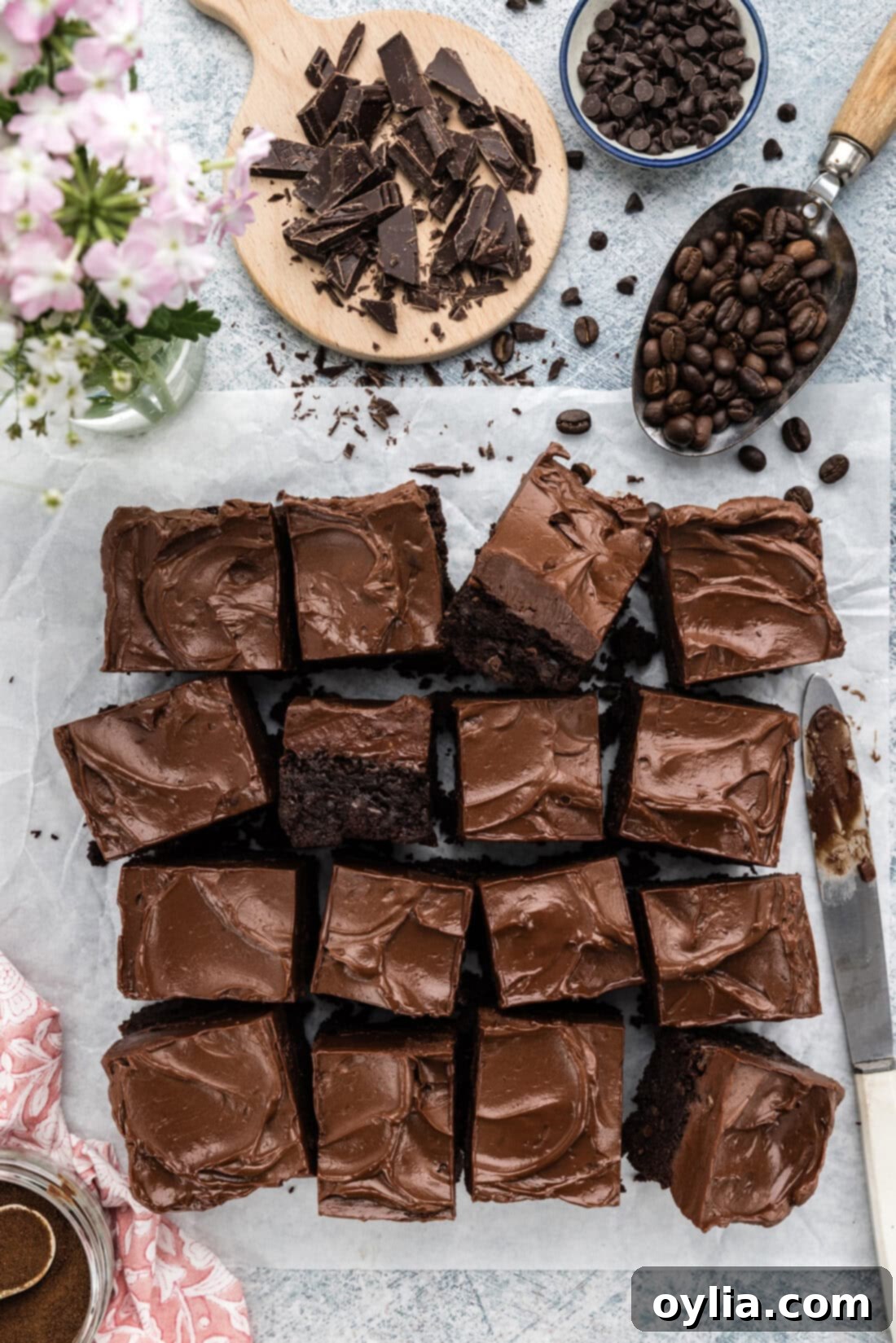Fudge Frosted Espresso Brownies cut into squares on parchment paper