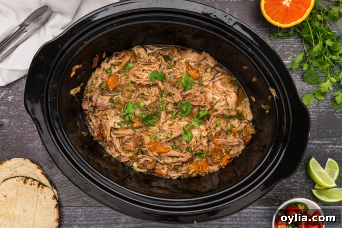 finished shredded carnitas in a crockpot with oranges