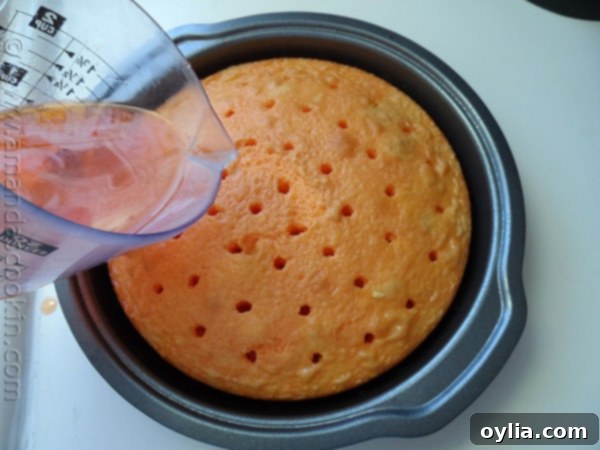 Step-by-step image: Using a wooden skewer to poke holes evenly into the baked orange cake layers, preparing them for gelatin absorption.