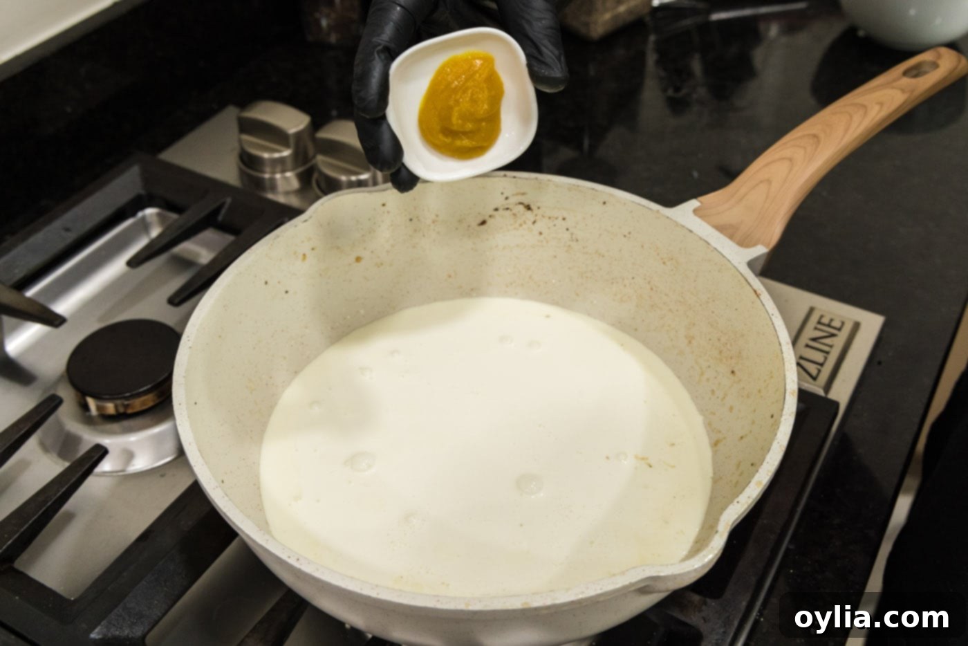 adding chicken base to heavy cream in skilet