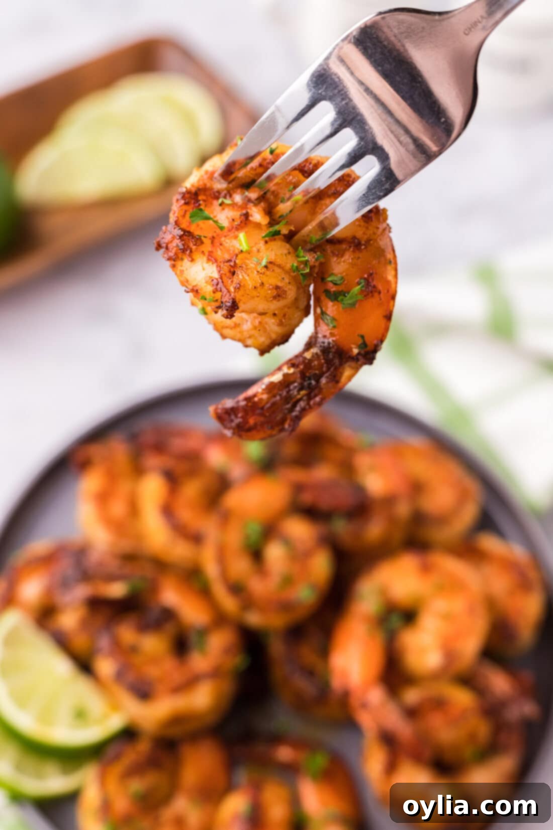 Close up shot of a single spicy shrimp on a fork, ready to eat
