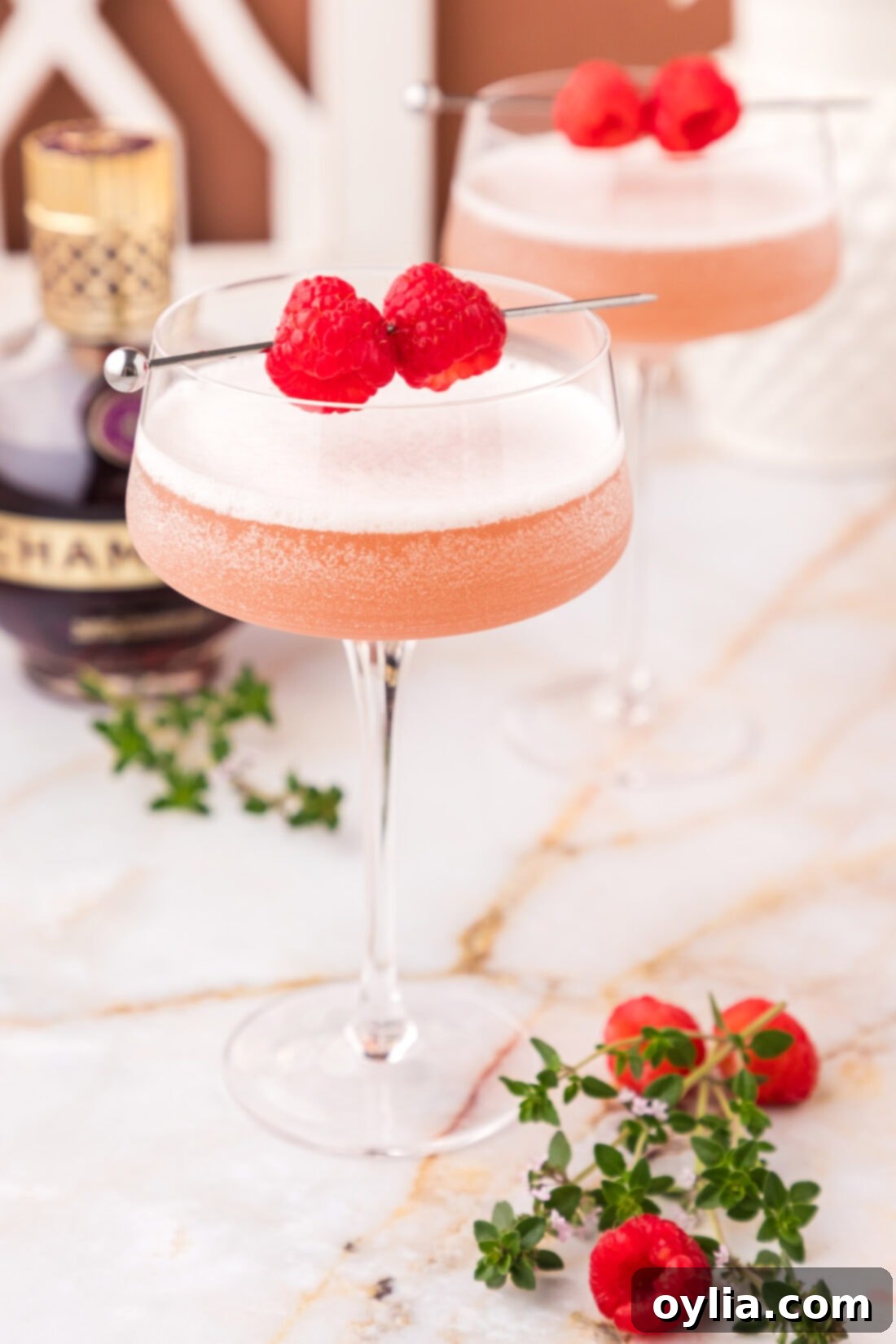 French Martini 2 Close up photo of two French Martinis, garnished with raspberries, showcasing their elegant pink color and frothy texture.