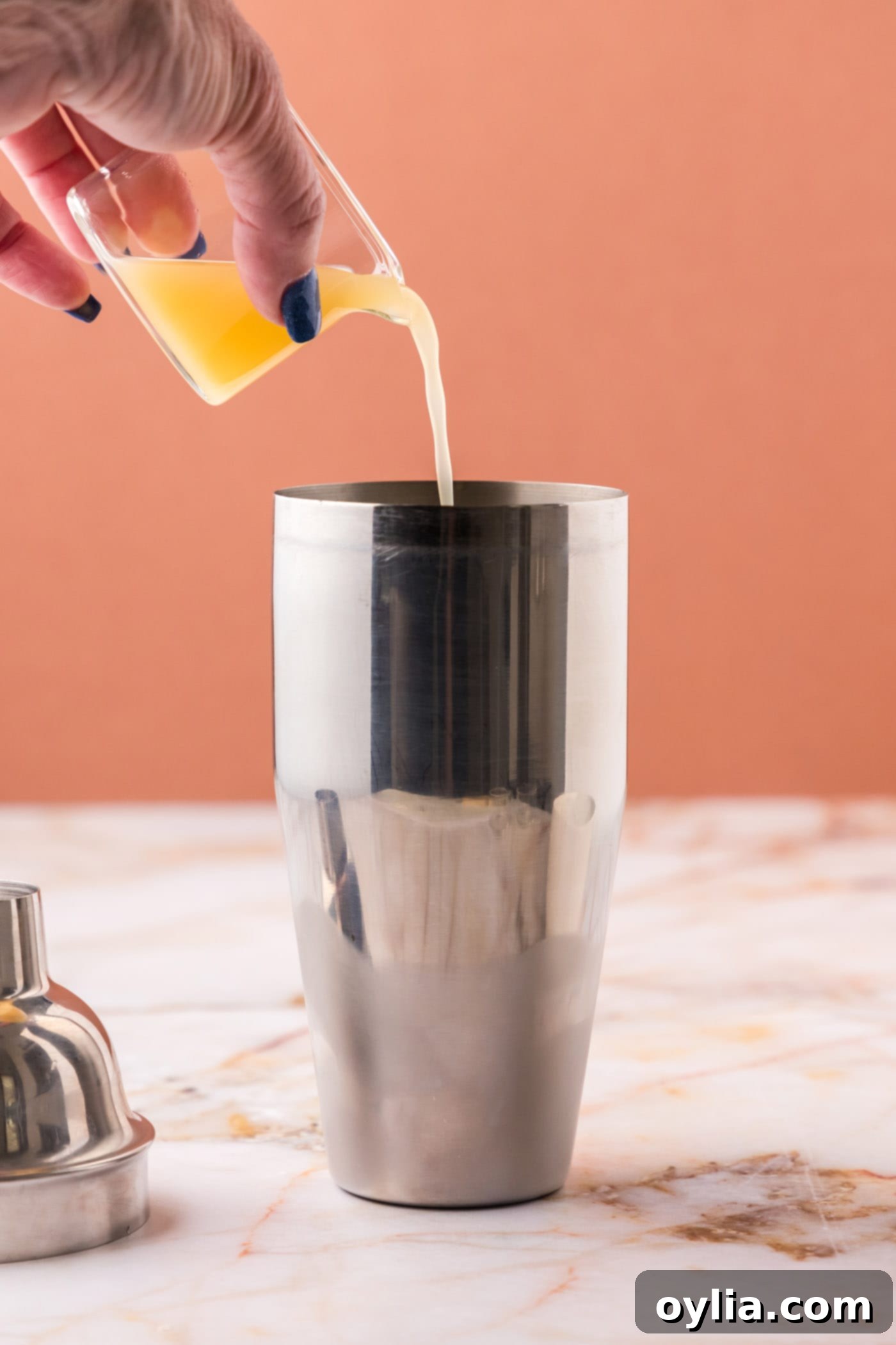 pouring pineapple juice into cocktail shaker