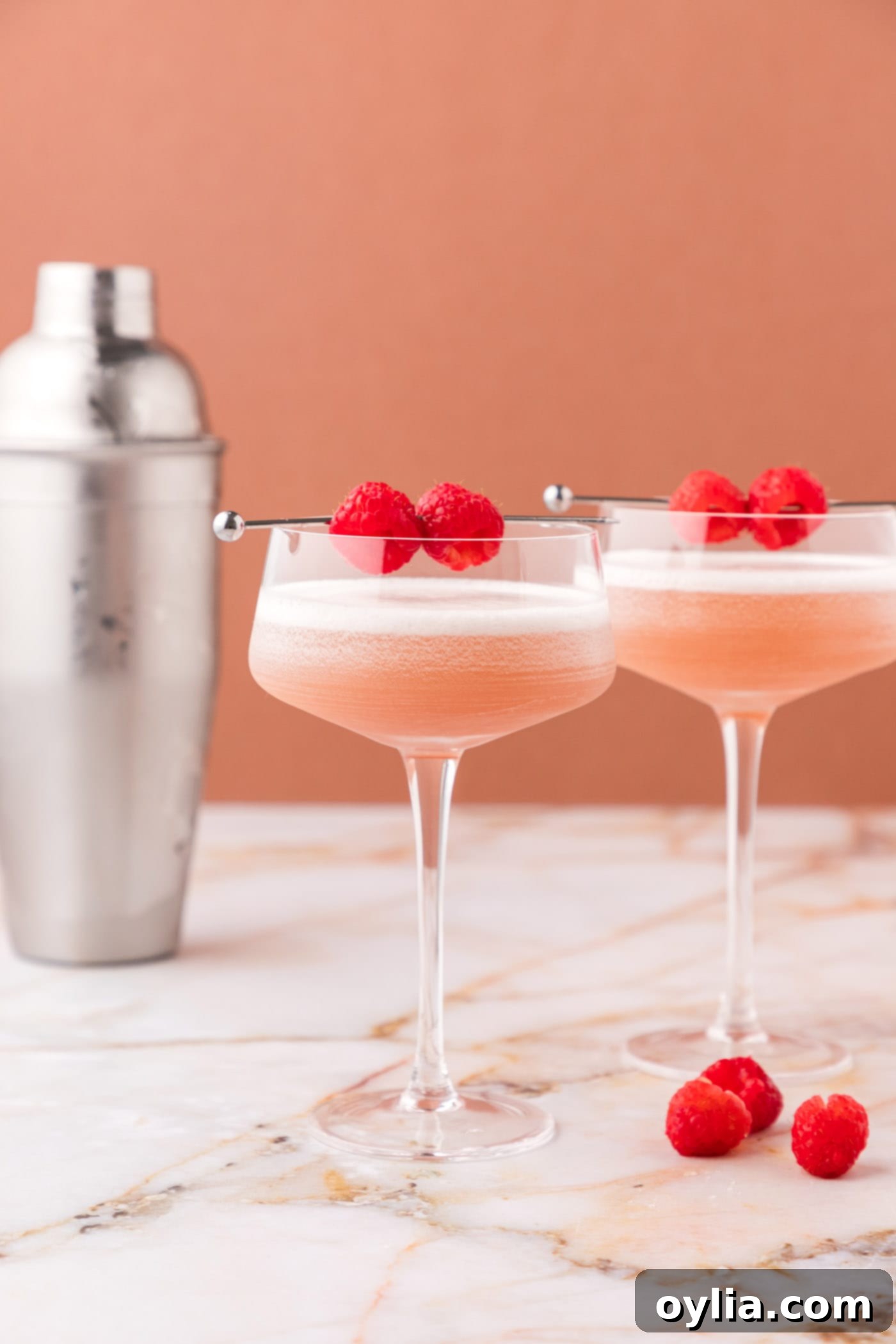 two french martinis with a garnish of fresh raspberries