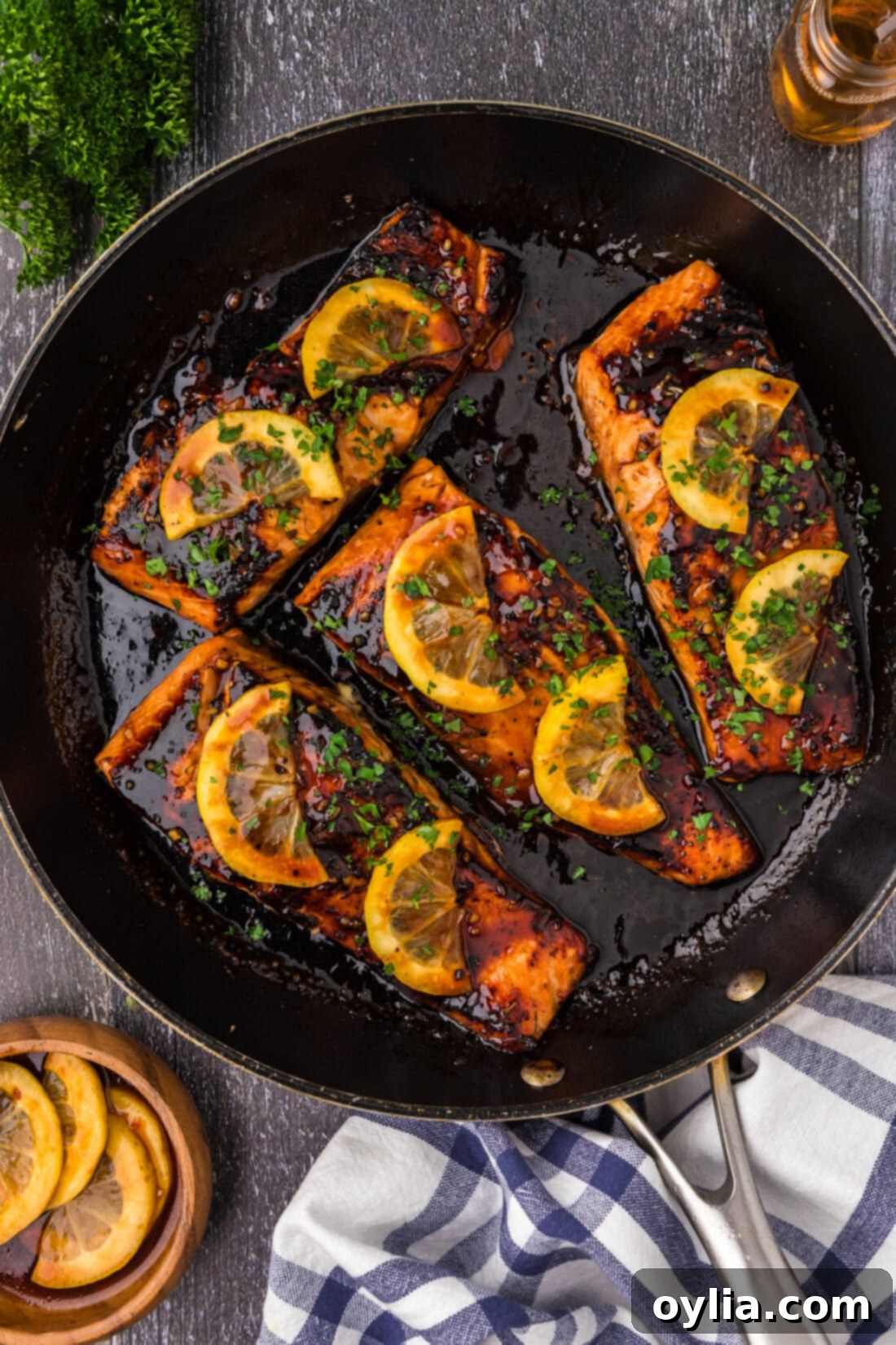 Honey Salmon in a skillet topped with lemon slices