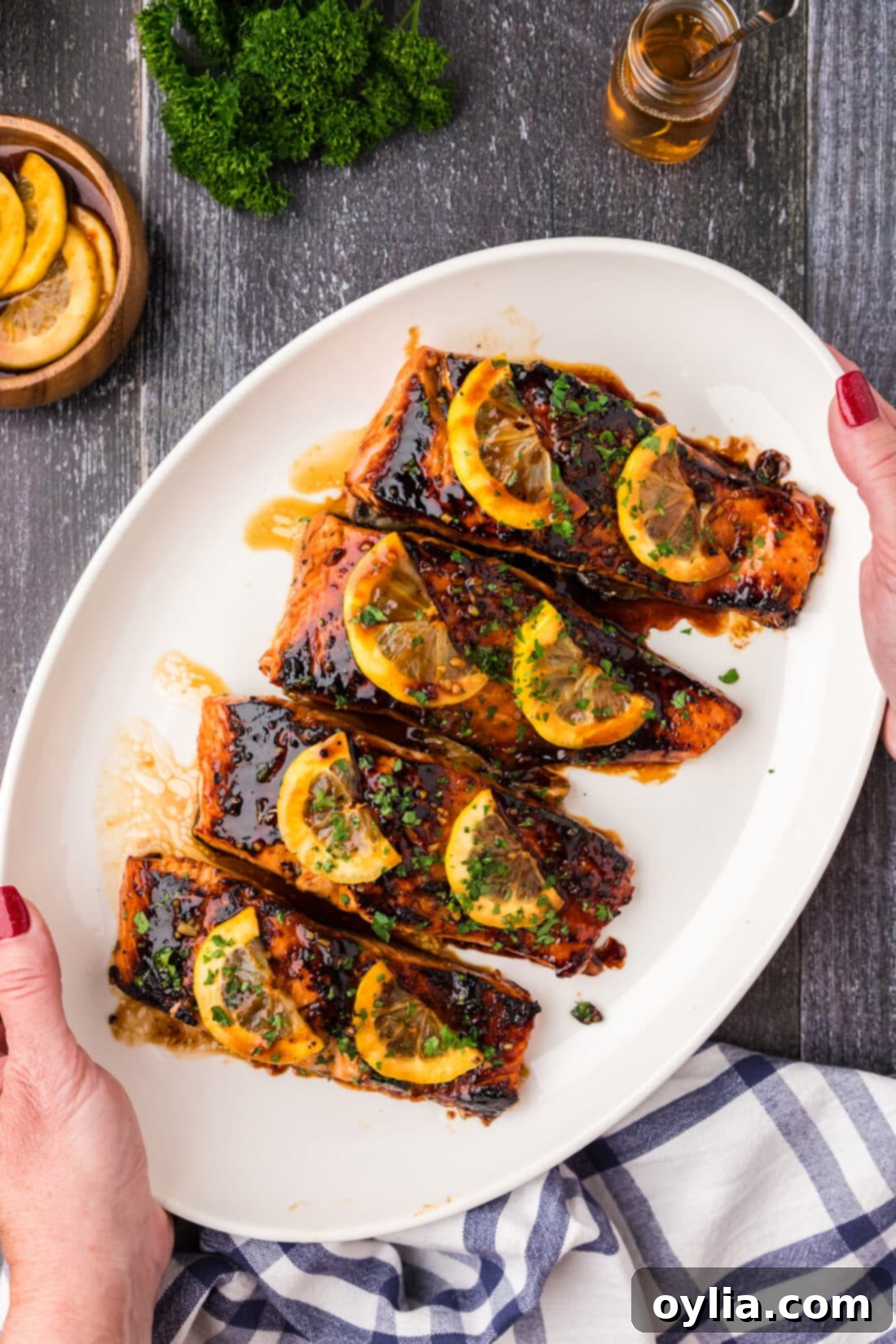 Hands holding a platter of Honey Salmon
