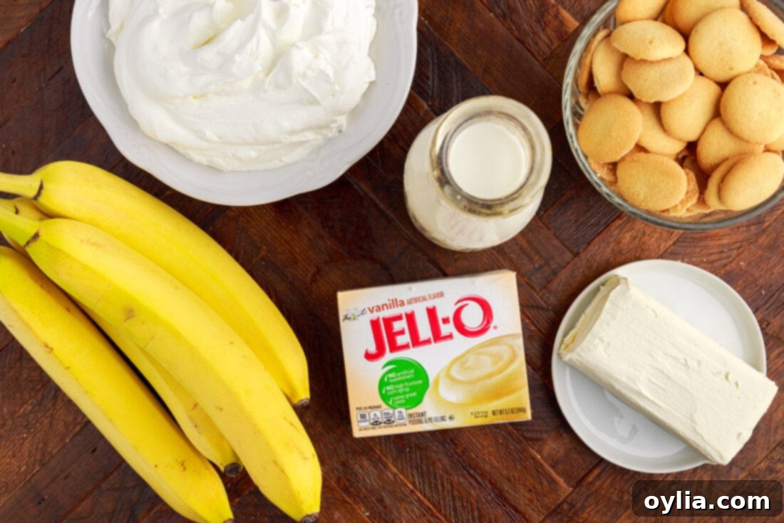 Banana Dream Trifle 4 Ingredients for Banana Trifle laid out: cream cheese, milk, pudding mix, bananas, Nilla wafers, and whipped cream