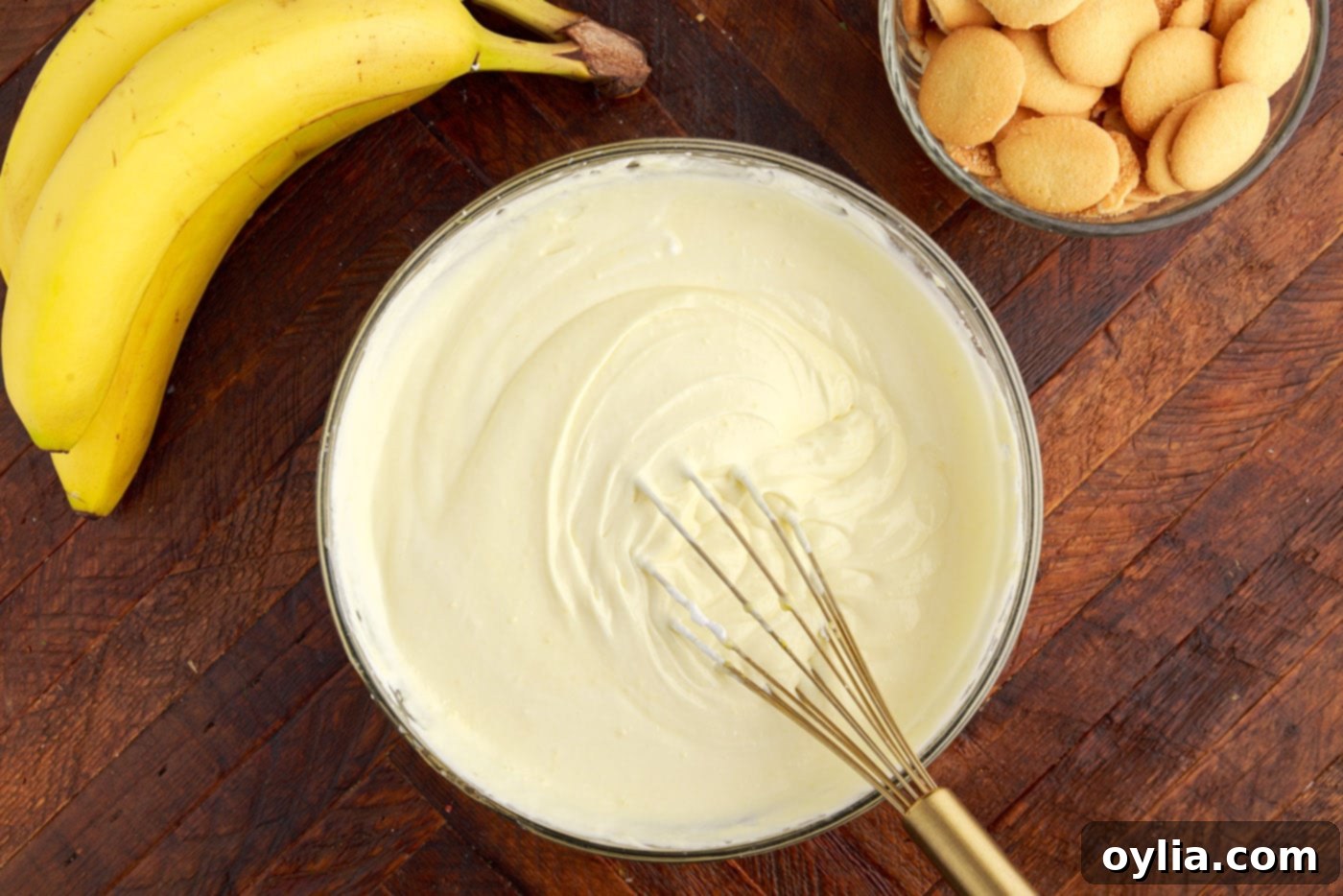 whipped cream cheese vanilla pudding mixture in a bowl with a whisk